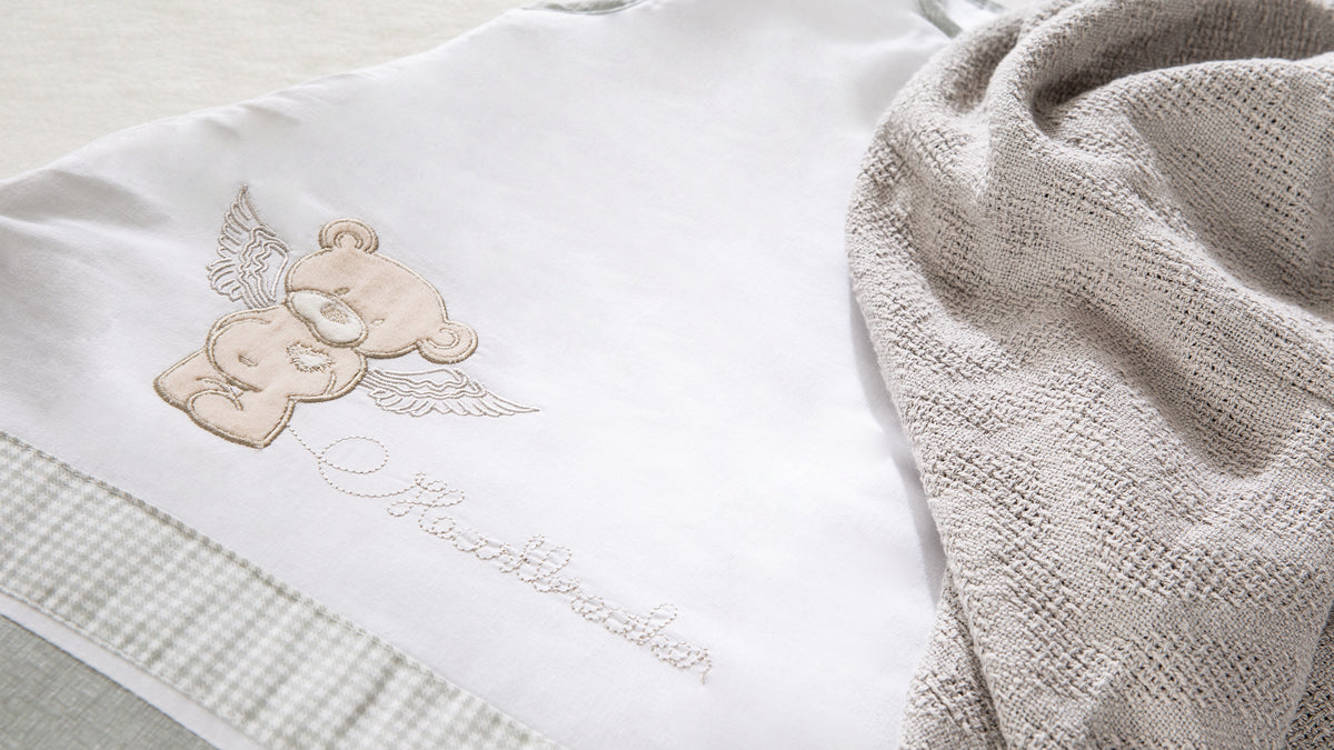 Vorschaubild Textilkollektion Heartbreakerbär mit Detailaufnahme eines Schlafsacks in Weiß / Beige mit Bären-Motiv