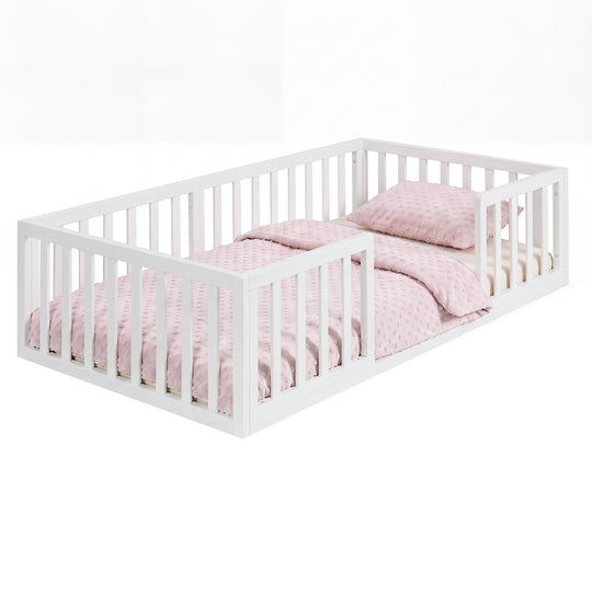 Lit bas laqué blanc, en bois, avec barrière de protection et linge de lit à pois roses, sur fond blanc. Entièrement généré par IA