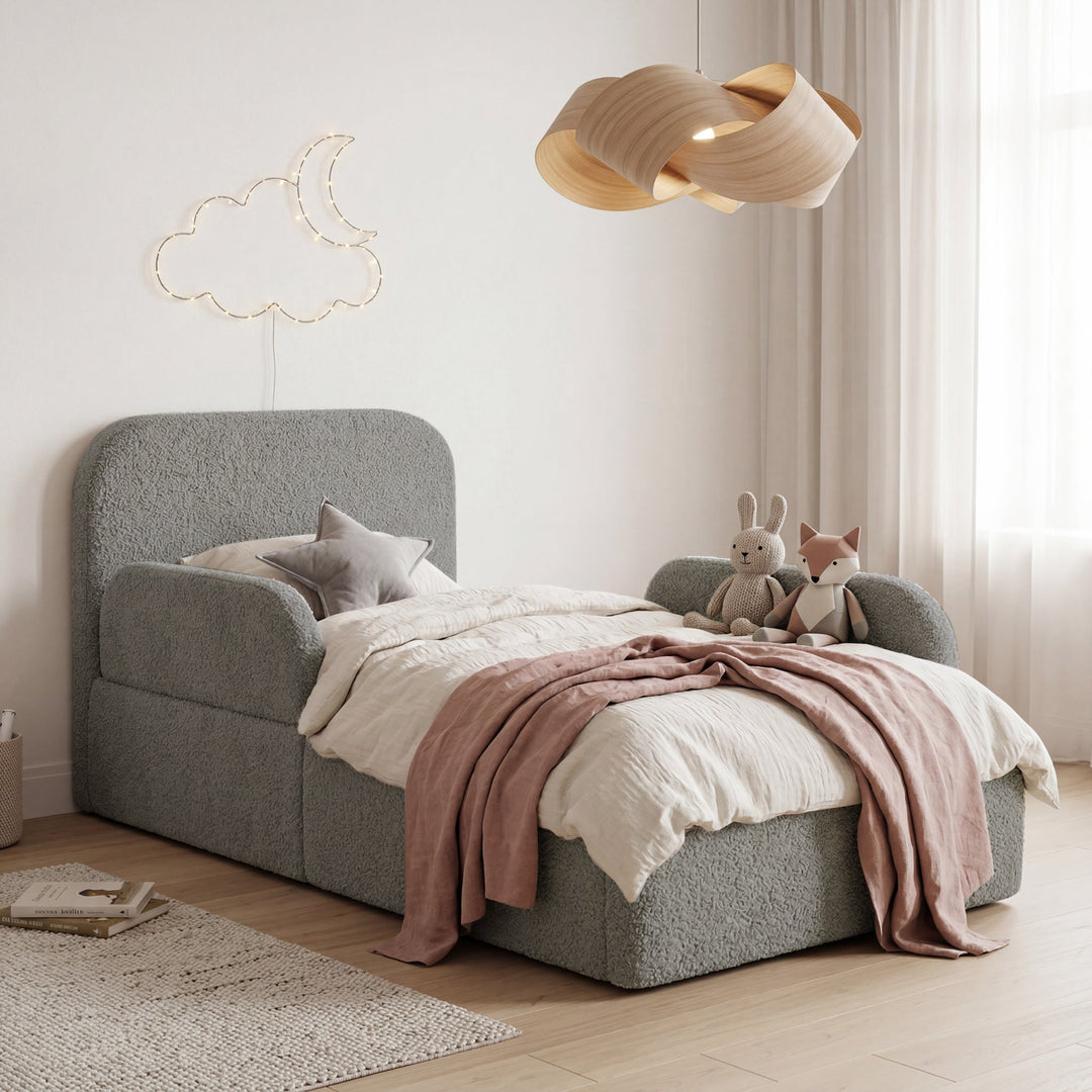 Cama infantil gris de bouclé con protección anticaídas, peluches y guirnalda de luces de luna y nubes en una habitación infantil. Generada íntegramente con IA.