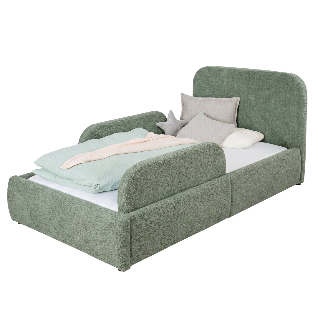 Cama infantil verde de bouclé con protección anticaídas y ropa de cama color menta, imagen recortada.