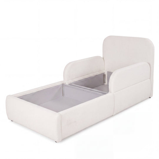 Cama infantil blanca de bouclé abierta con el arcón de almacenaje visible, imagen recortada.