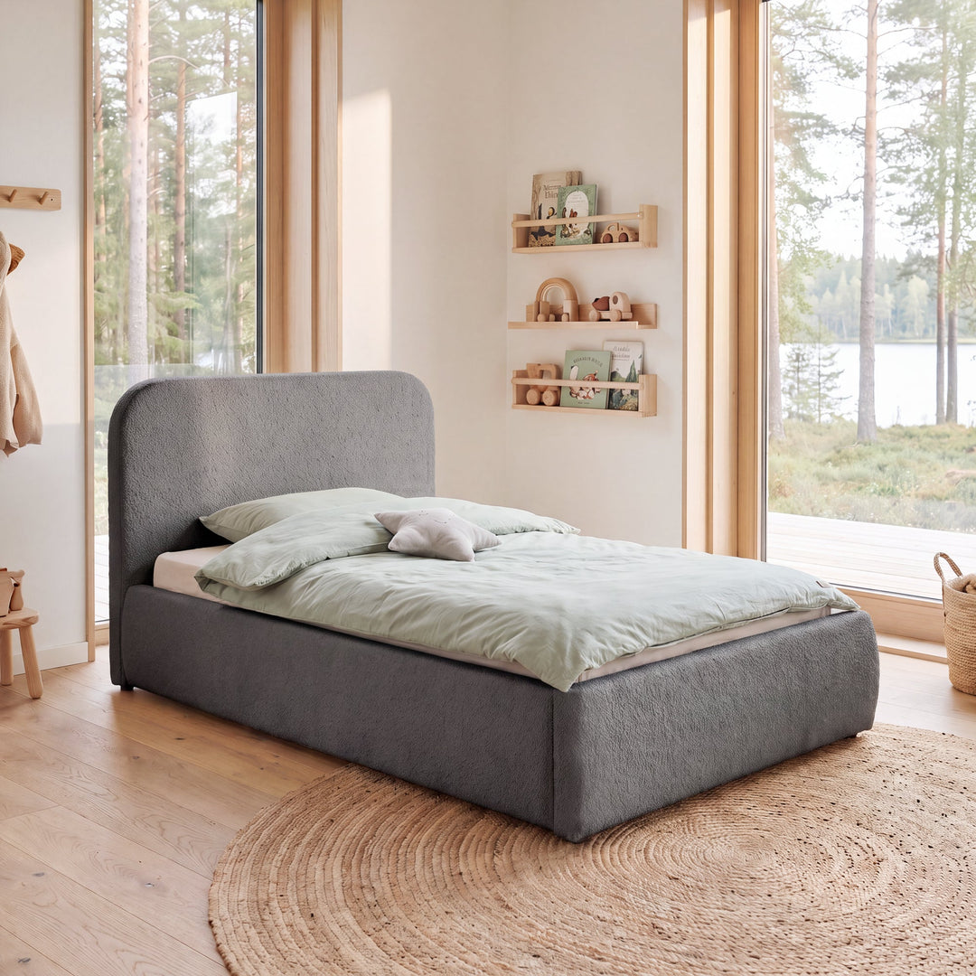 Grey bouclé bed in front of a window front with wall shelves and forest view. Fully AI-generated.