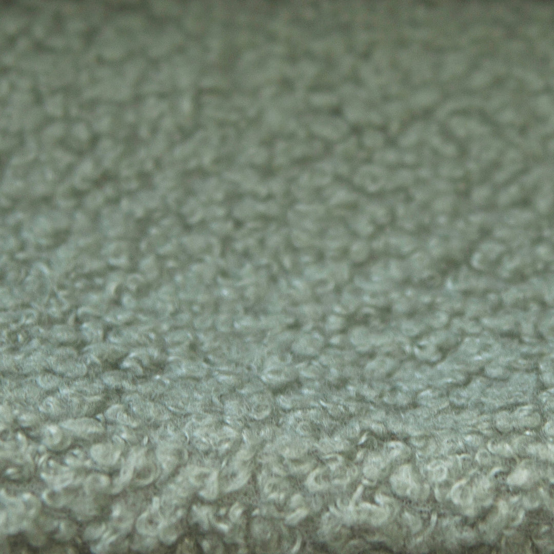 Close-up of the green bouclé fabric cover of the roba Little Dream children's bed. Partially AI-generated.