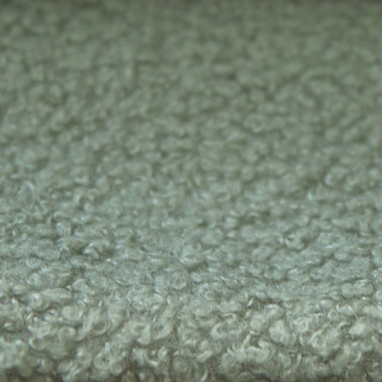 Close-up of the green bouclé fabric cover of the roba Little Dream children's bed. Partially AI-generated.