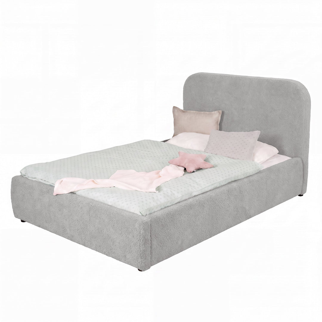 Cama infantil roba Little Dream gris claro con cabecero tapizado, vestida con ropa de cama de lunares y cojines. Generada parcialmente con IA.