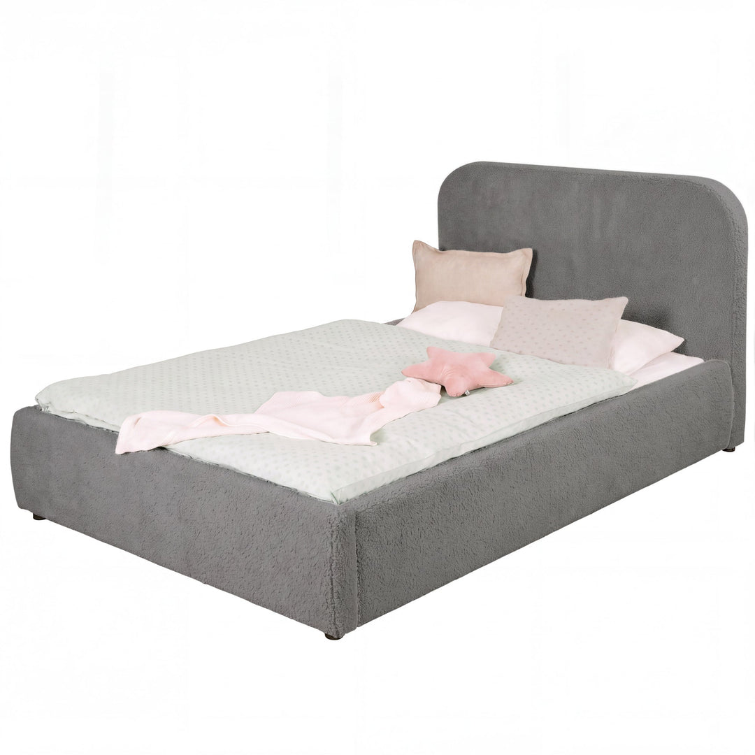 Cama infantil roba Little Dream antracita con cabecero tapizado, vestida con ropa de cama de lunares y cojines. Generada parcialmente con IA.