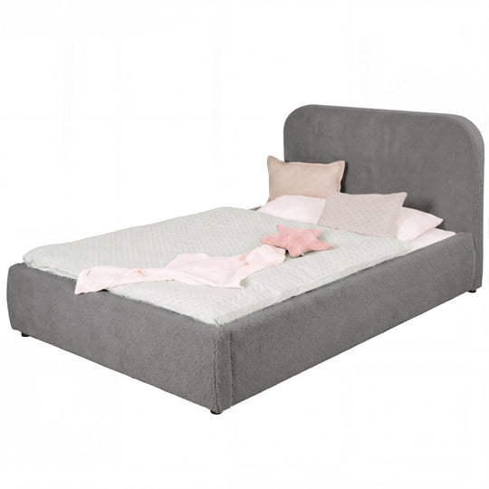Cama infantil roba Little Dream antracita con cabecero tapizado, vestida con ropa de cama de lunares y cojines. Generada parcialmente con IA.