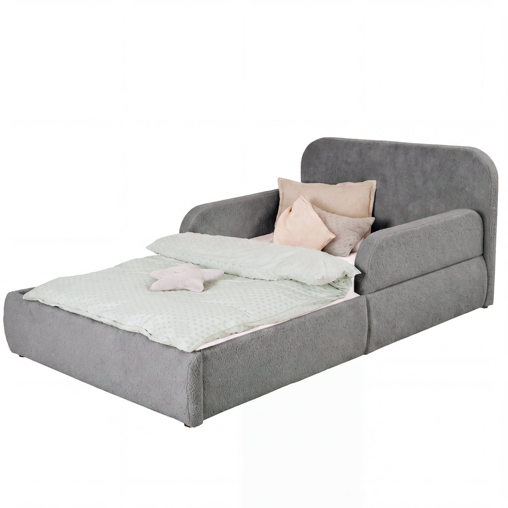 Cama infantil roba Little Dream antracita con cabecero y protecciones laterales, vestida con ropa de cama y cojines. Generada parcialmente con IA.
