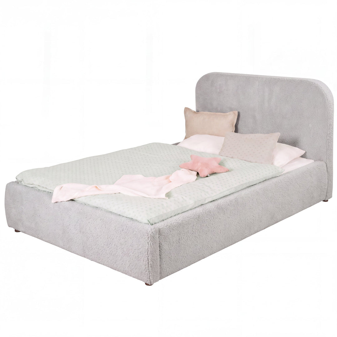 Cama infantil roba Little Dream gris claro con cabecero tapizado, vestida con ropa de cama de lunares y cojines. Generada parcialmente con IA.