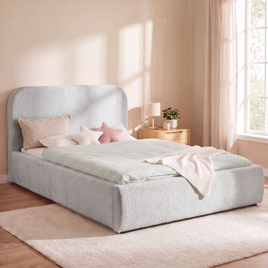 Cama infantil roba Little Dream gris claro en un dormitorio luminoso con mesita de noche y lámpara de lectura. Generada parcialmente con IA.