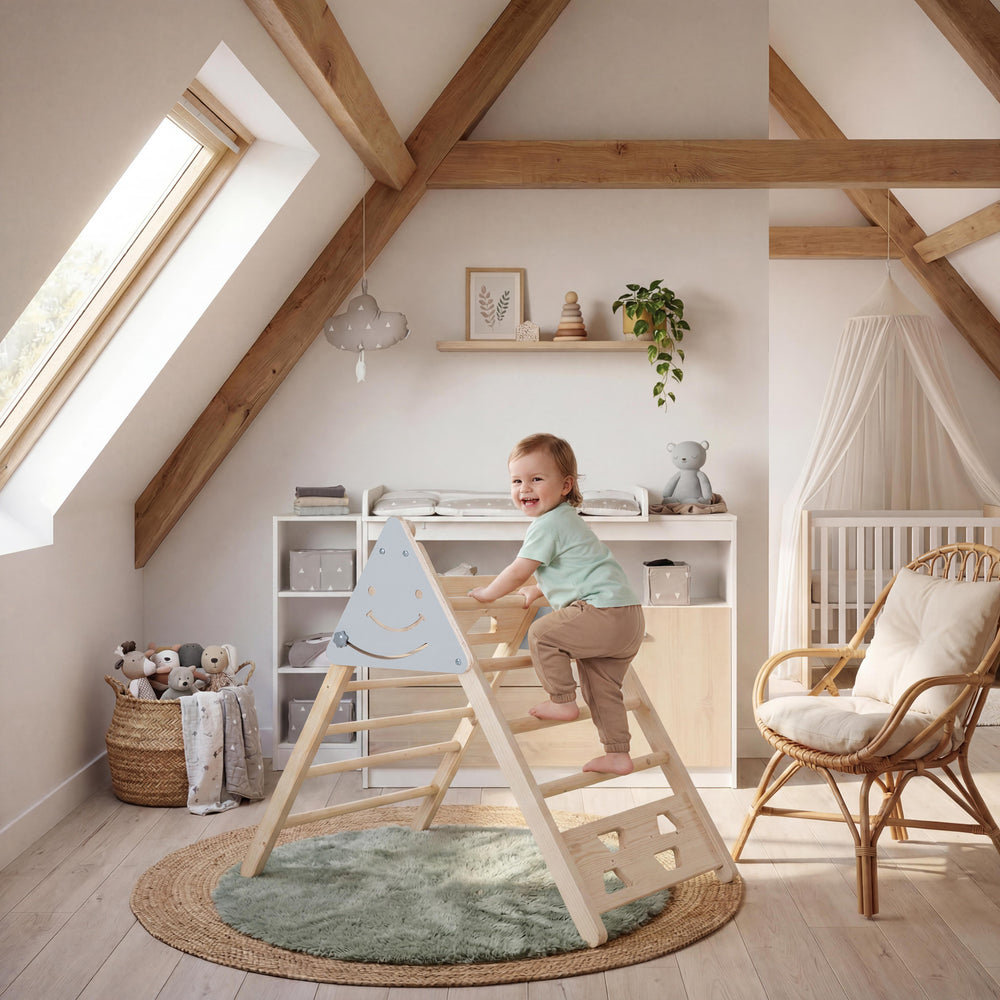 Lifestyle-Bild: Barfüßiges Kleinkind in mintgrünem Shirt klettert lachend auf dem Kletterdreieck aus Massivholz in einem hellen Dachzimmer mit Holzbalken, Wickelkommode, Babybett mit Himmelbett-Baldachin und grünem Rundteppich.