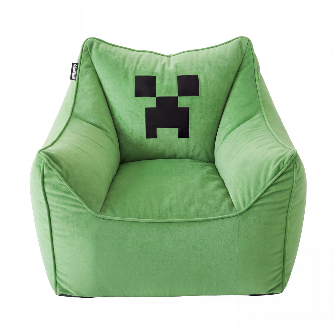 Grüner Sitzsack-Sessel mit Armlehnen und schwarzem Creeper-Pixelgesicht auf der Rückenlehne, Frontansicht vor Weiß. Vollständig KI generiert.