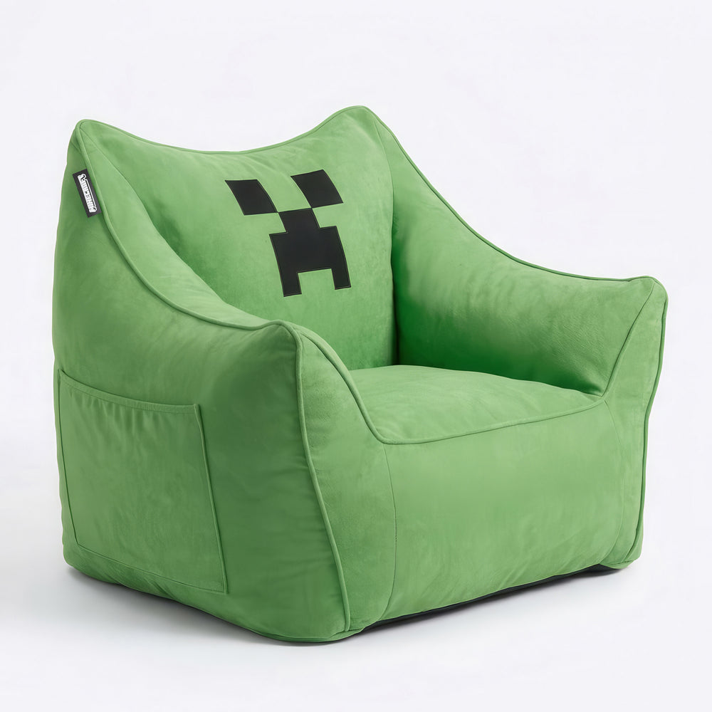 Grüner Sitzsack-Sessel mit Creeper-Pixelgesicht in Schrägansicht, an der Seite eine aufgesetzte Tasche, vor Weiß. Vollständig KI generiert.
