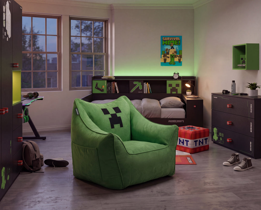 Grüner Sitzsack-Sessel mit Creeper-Gesicht im abendlichen Kinderzimmer mit grüner LED-Beleuchtung und dunklen Möbeln. Vollständig KI generiert.