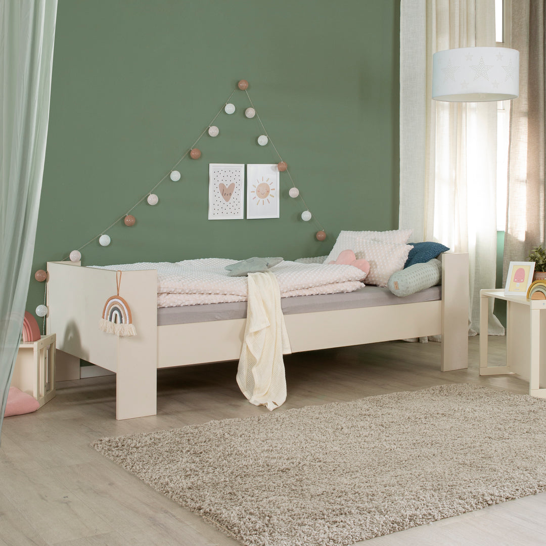 Einzelbett 90 x 200 cm 'Flexi Grow' in Cashmere im Kinderzimmer mit grüner Wand, Regenbogen-Applikation am Bettrahmen und Dekoration